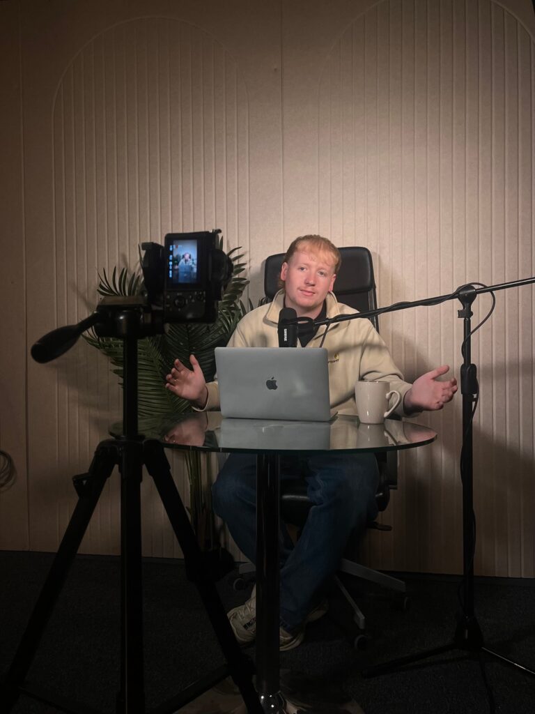 Presenter recording a video podcast with camera and microphone at Powerhouse Studios