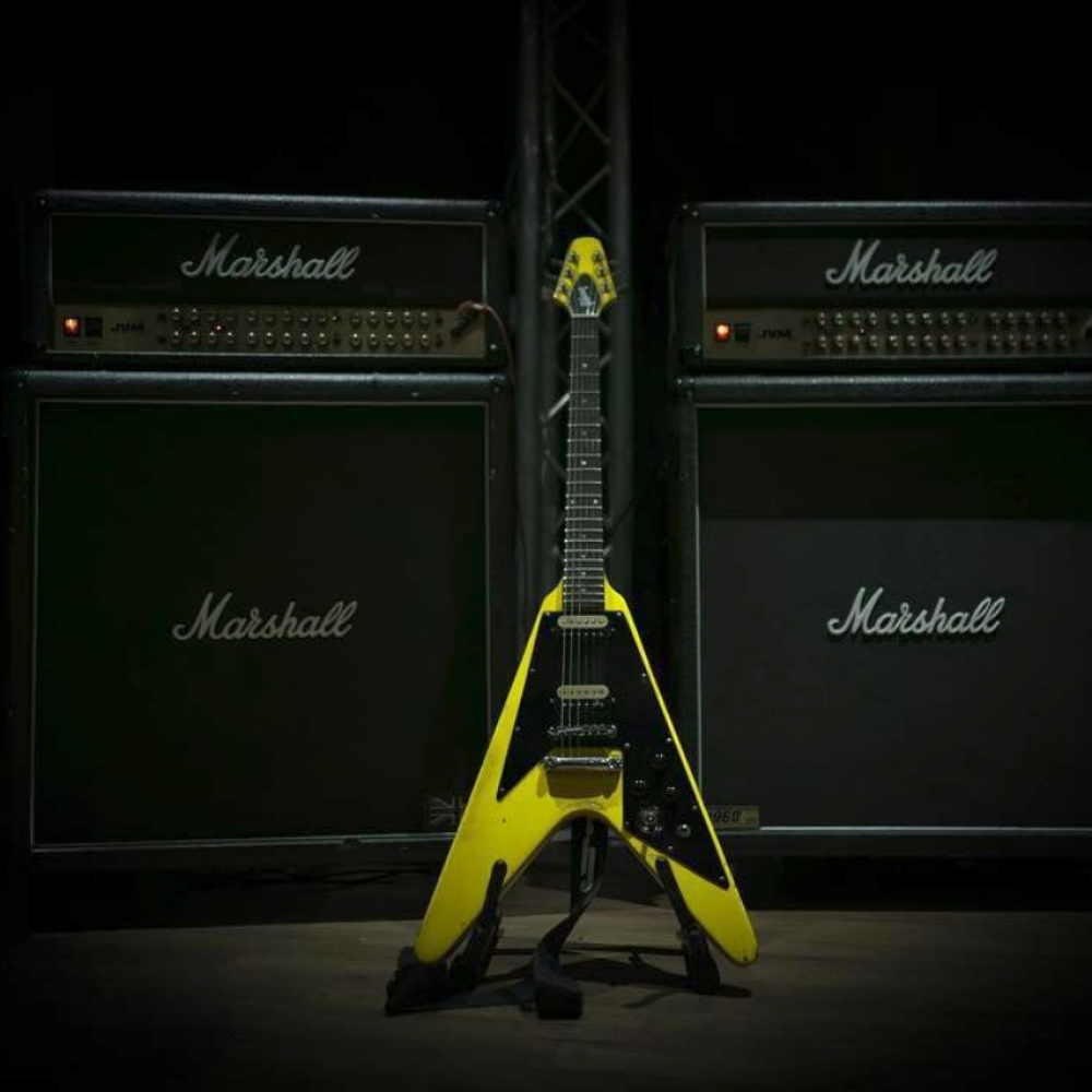 Photo of a yellow flying V guitar in front of Marshall Amps at Powerhouse Studios Surrey